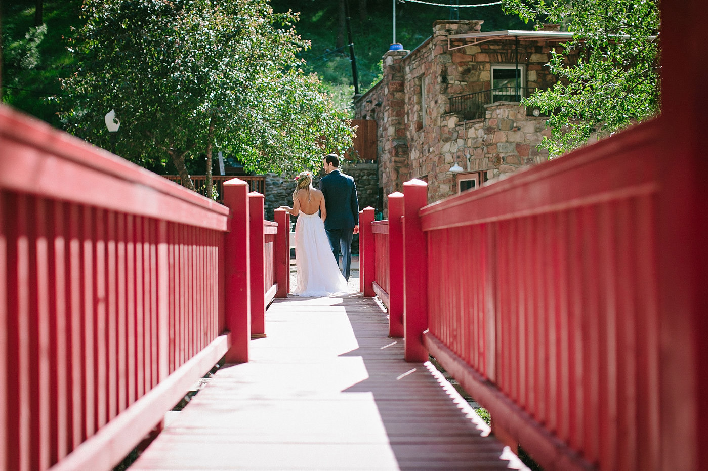Married couple walking across a bridge over 4 mile creek in Boulder