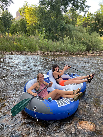 Two girls tubing on the St Vrain River through Lyons Colorado