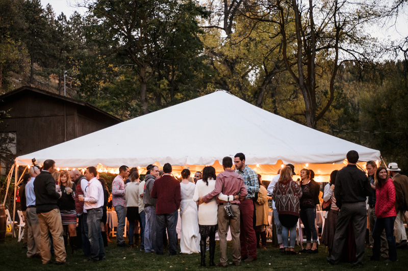 Outdoor tent reception at A-Lodge Boulder Colorado destination wedding venue with guests gathered on the canyon lawn