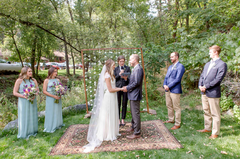 Outdoor destination wedding ceremony at A-Lodge Boulder Colorado beside Fourmile Creek
