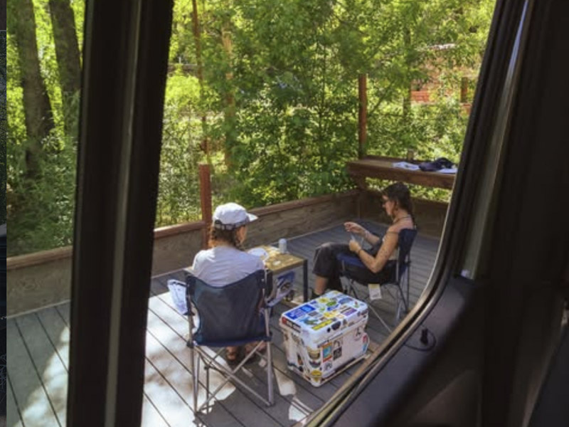 Two women vanlifers relaxing at their van camping site in Boulder at the A-Lodge